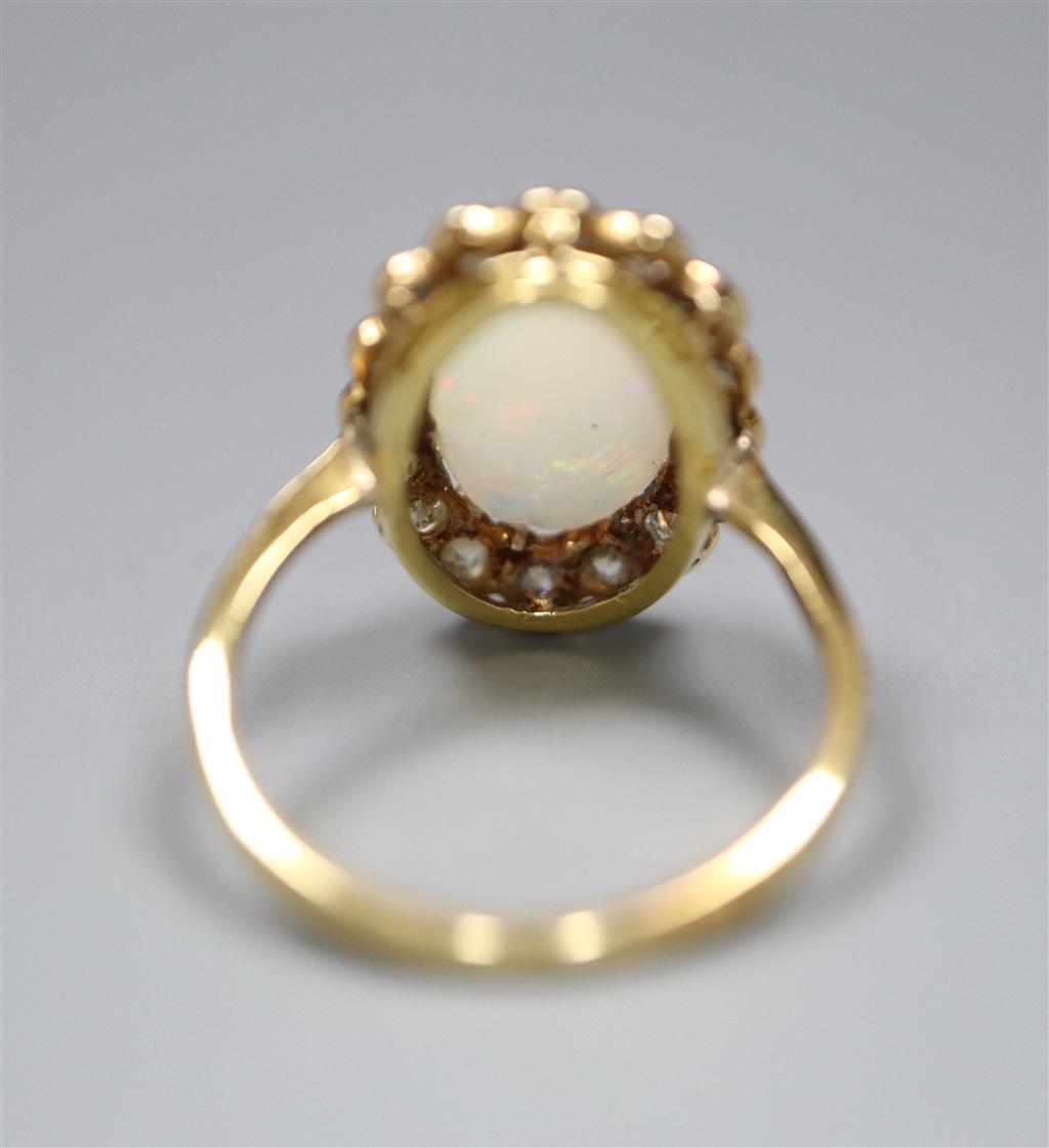 An early to mid 20th century 18ct, white opal and diamond set oval cluster ring, size K, gross 3.1 grams.